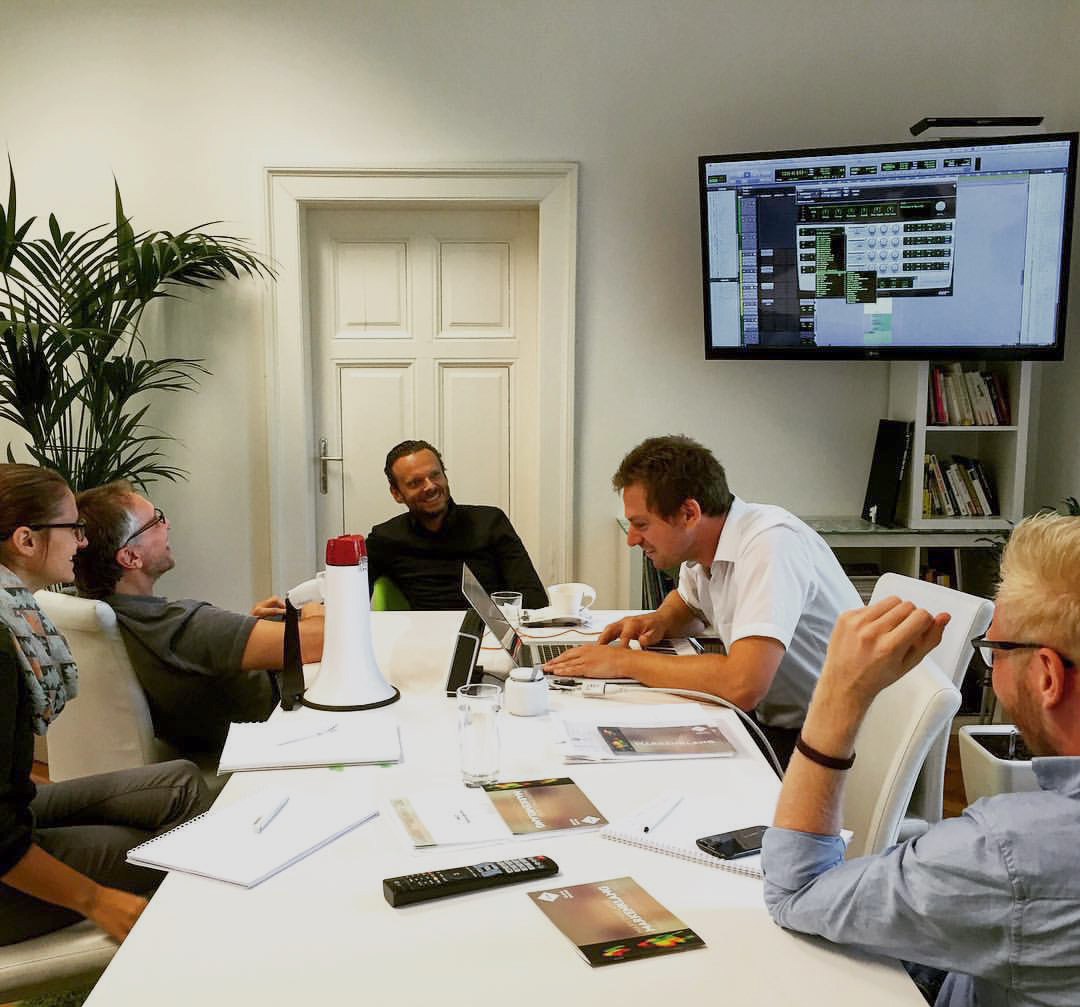 A collaborative team workshop gathered around a conference table.
